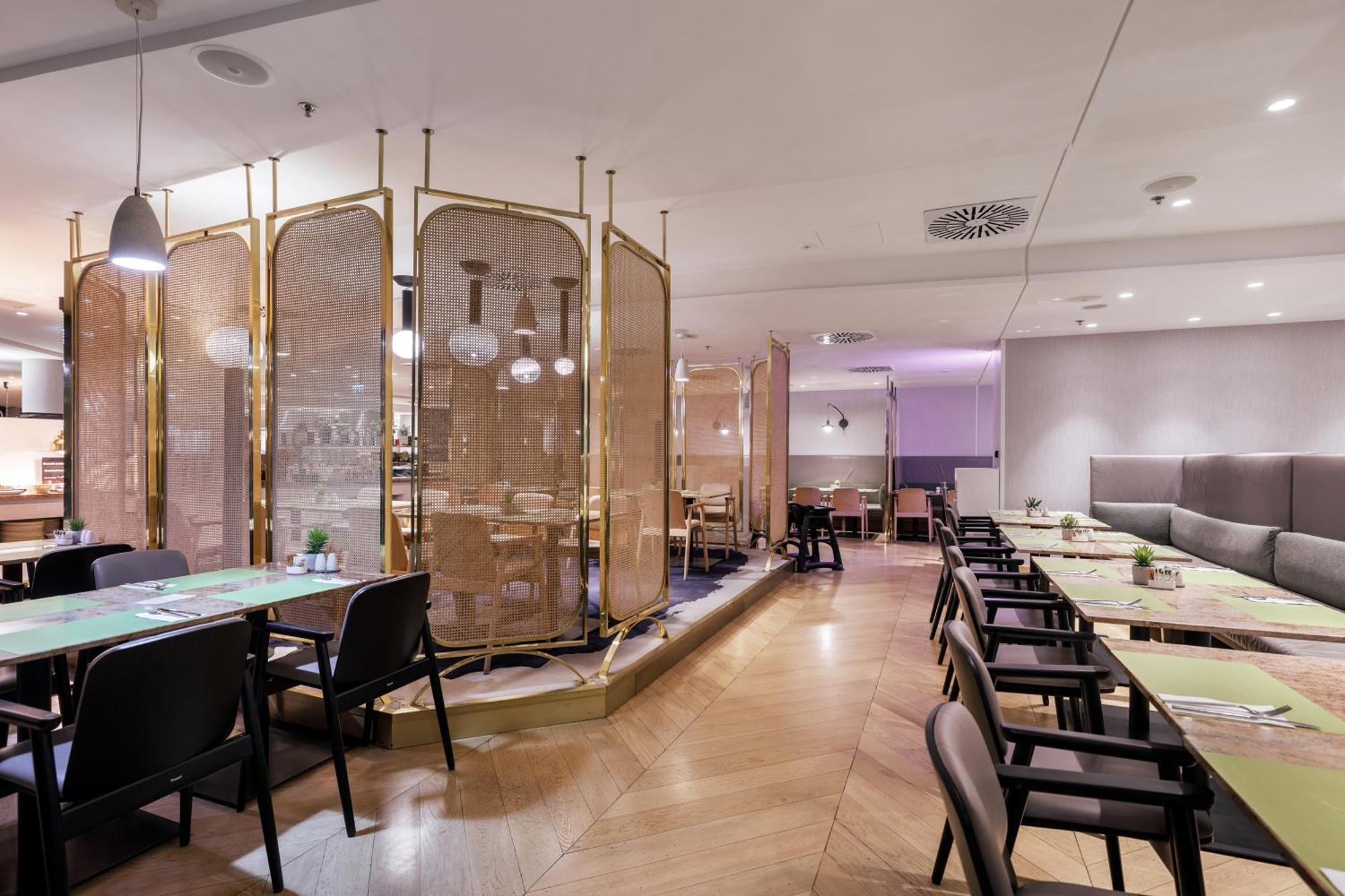 Radisson Blu Resort Świnoujście Exterior foto The photo depicts a modern restaurant interior. It features a layout with several tables and chairs arranged in an organized manner. There is a decorative partition made of delicate mesh or fabric, providing some privacy between different dining area