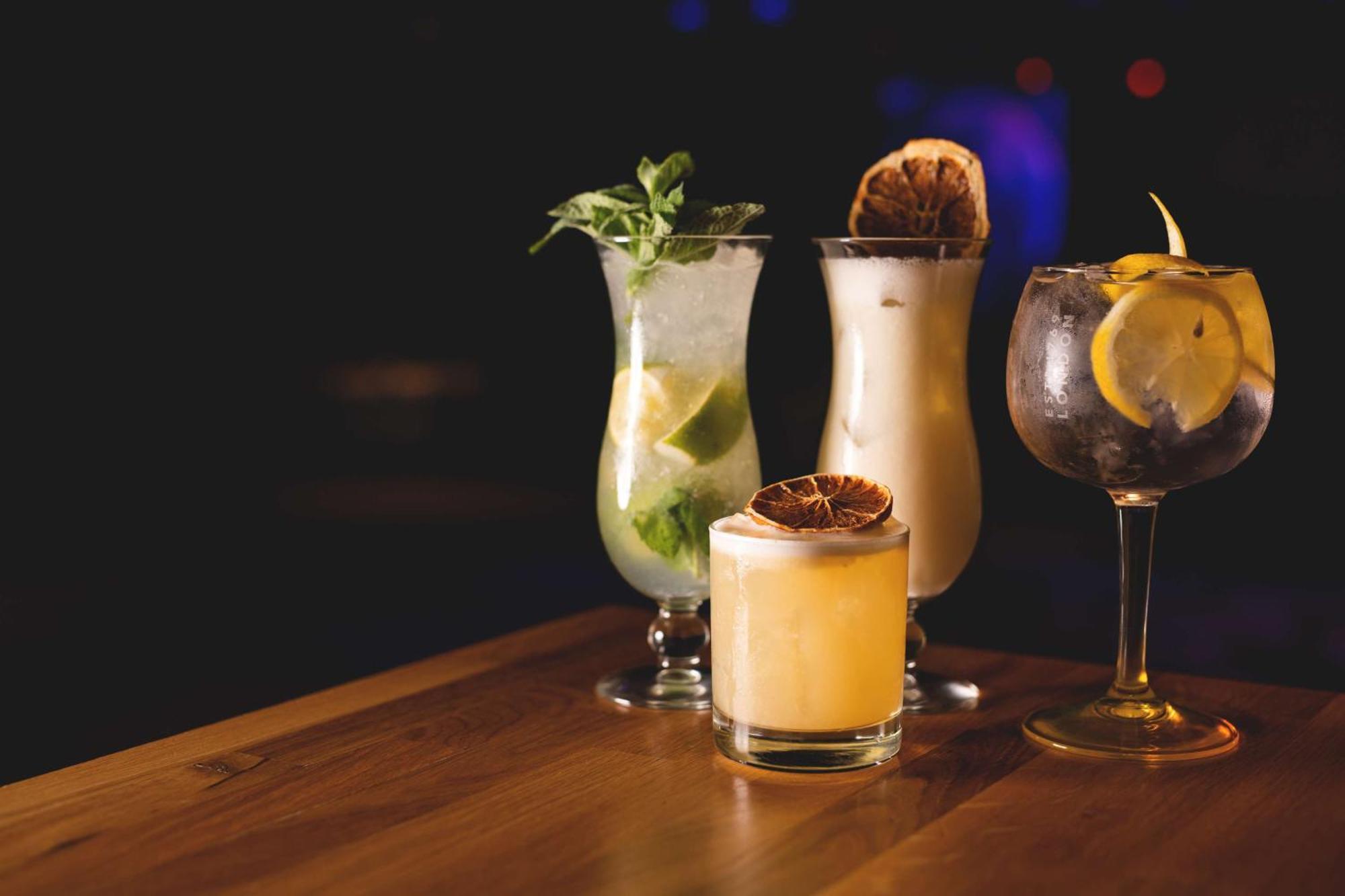 Radisson Blu Resort Świnoujście Exterior foto The photo showcases a collection of four different cocktails displayed on a wooden table. 

1. **Mojito**: A tall glass filled with lime slices, mint leaves, and a clear liquid, likely rum-based, garnished with fresh mint.
2. **Creamy Cocktail**: A s