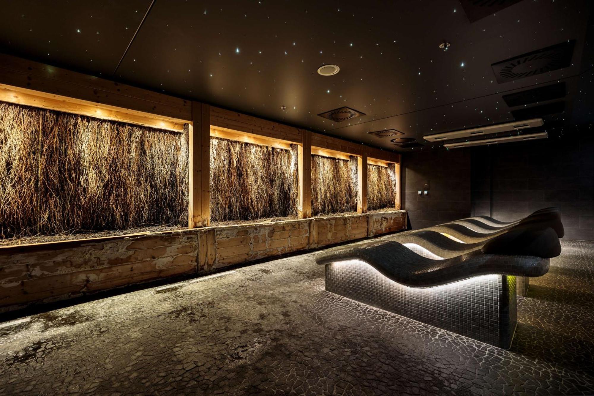 Radisson Blu Resort Świnoujście Exterior foto The photo depicts a modern, serene spa or relaxation space. It features several wooden-framed windows that showcase natural elements, possibly dried grass or plants, creating a calming atmosphere. The walls are dark, and the ceiling may have lights r