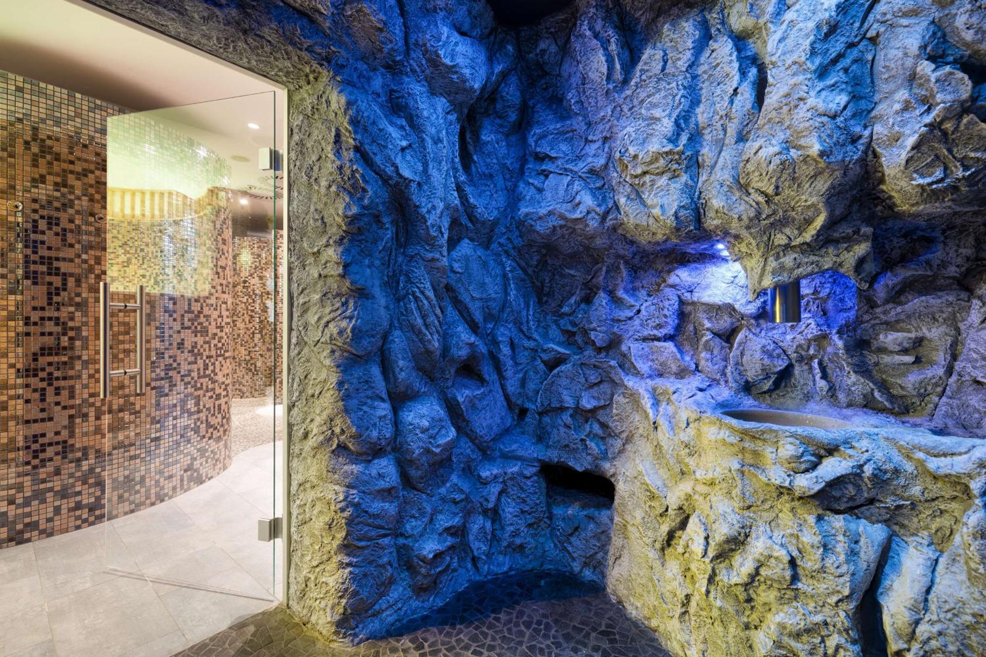 Radisson Blu Resort Świnoujście Exterior foto The photo shows a spa-like environment with a cave-like design. The walls are styled to resemble natural rock formations, featuring textures and colors that suggest a stone surface. Soft blue lighting highlights the contours of the rocks, creating a 